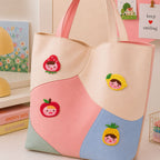 strawberry lemon apple and pineapple girl face stick-on patches decorating a pink and cream wave color-block leather handbag