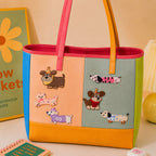 party hat dog dachshund in sweater bow and plaid outfit stick-on patches decorating a multicolor stripe leather handbag