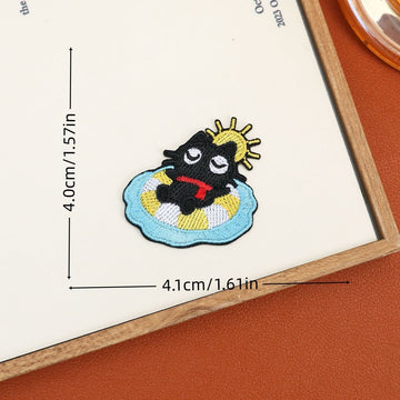 Black cat embroidered stick-on patch lounging on a blue-and-yellow pool float beneath a sun
