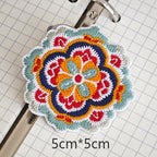 Four-lobed floral embroidered stick-on patch with navy-bordered petals
