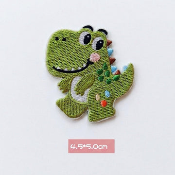 green T-Rex kawaii embroidered stick-on patch — green tyrannosaurus facing forward both arms raised wide smile bright eyes