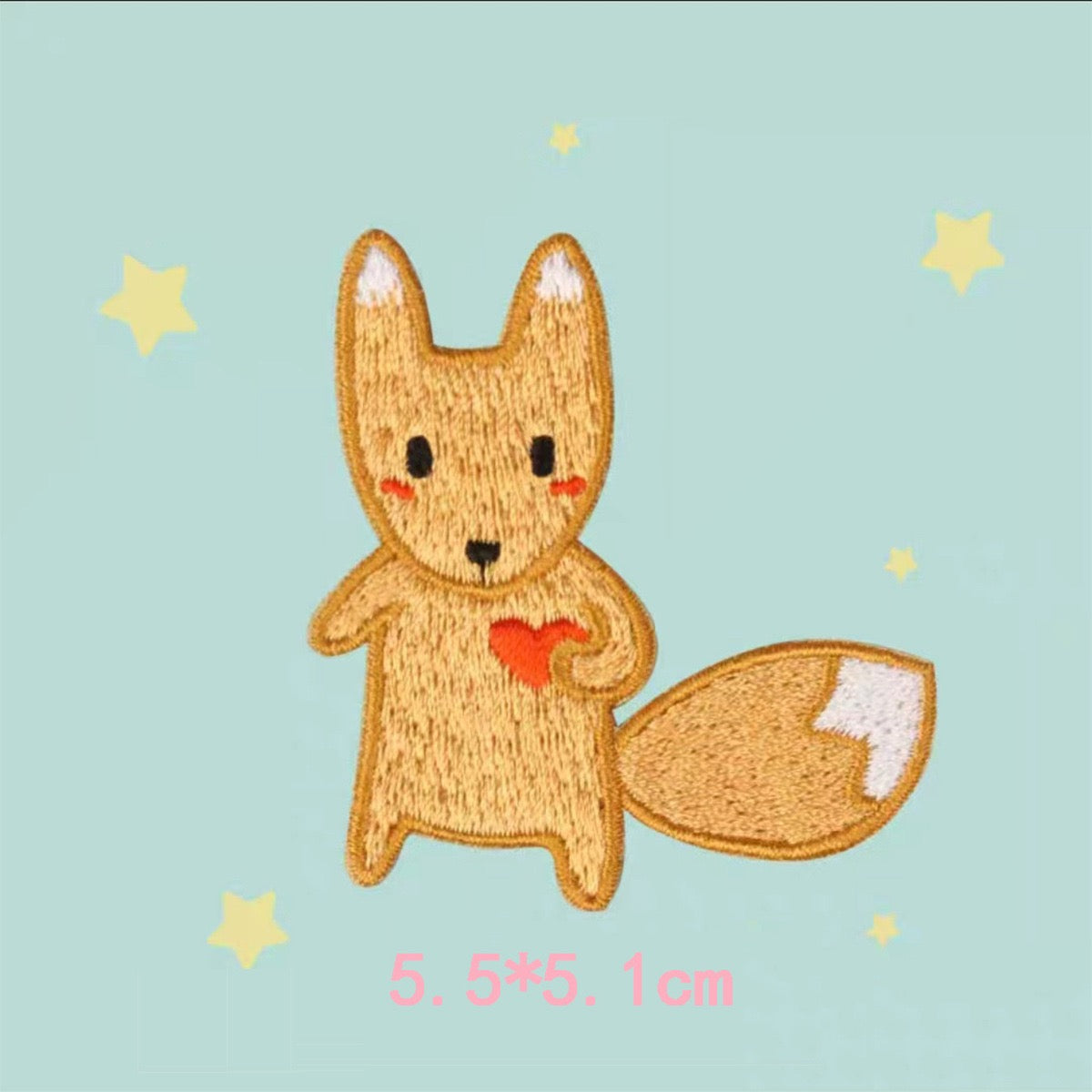 Golden-orange fox embroidered patch holding a red heart with a large white-tipped tail

