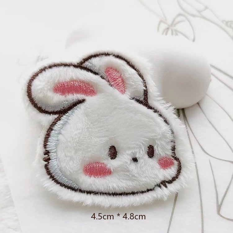 white bunny head embroidered stick-on patch — close-up round white bunny face ears up soft fluffy velvety texture
