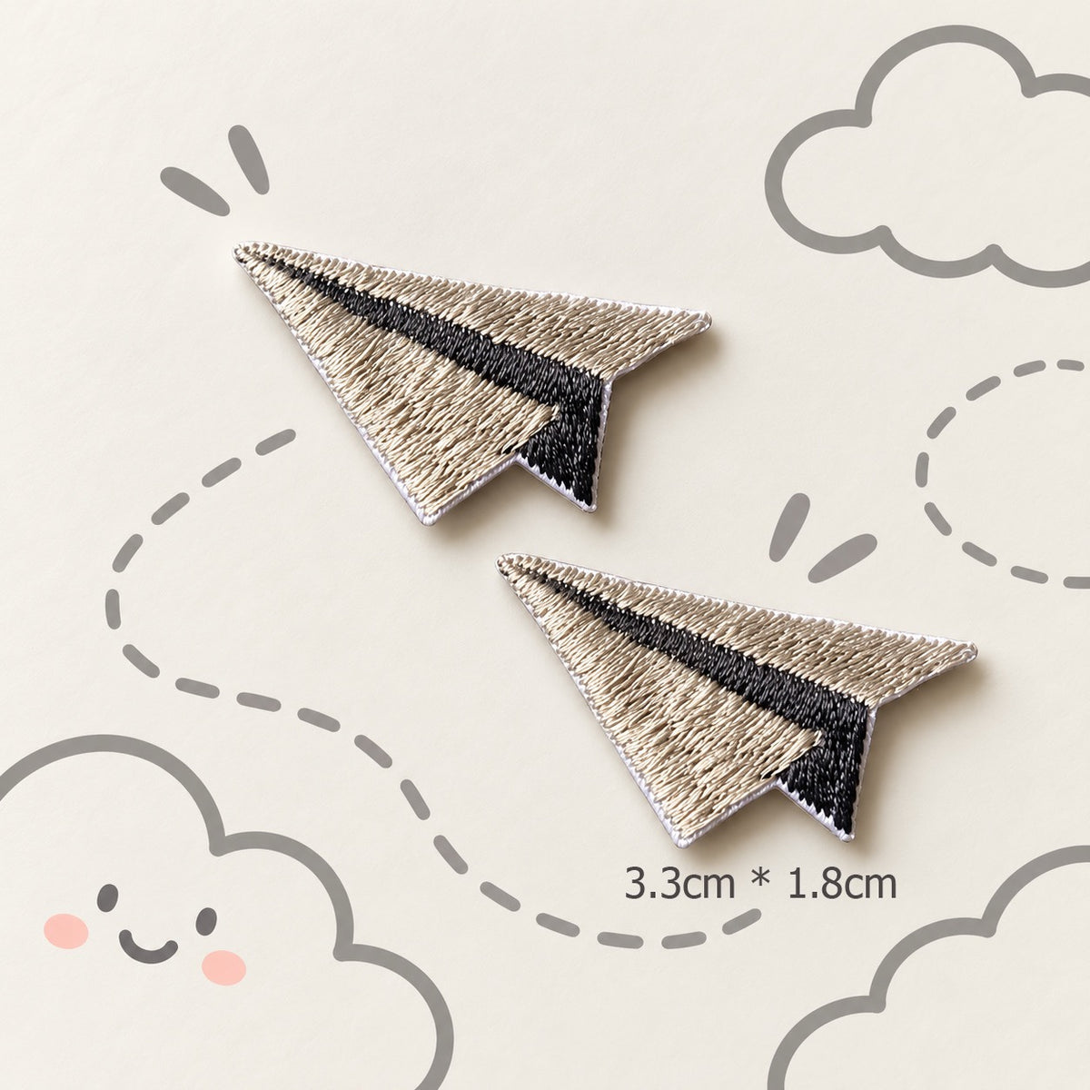 grey paper airplane embroidered stick-on patches — pair of silver grey satin embroidery paper planes with dark grey fold crease detail 33x18mm