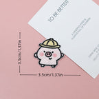 Pink piglet embroidered stick-on patch with raised arms and a pale yellow bucket hat
