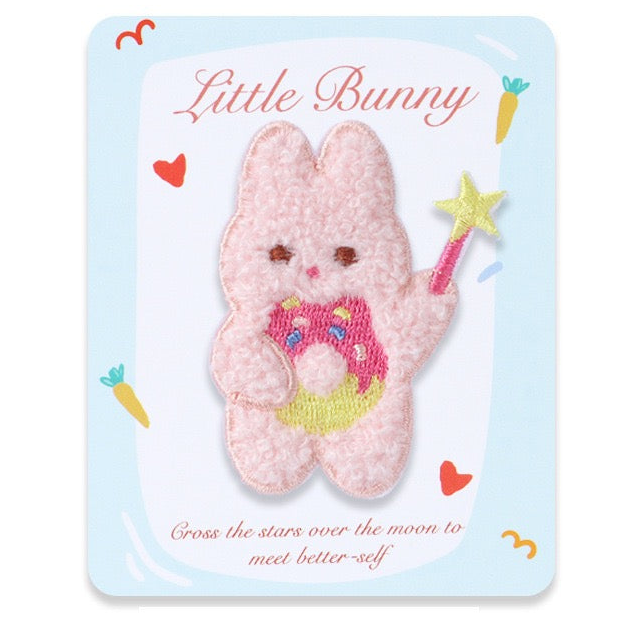 Fluffy pink bunny patch holding a star wand and frosted donut on a Little Bunny display card
