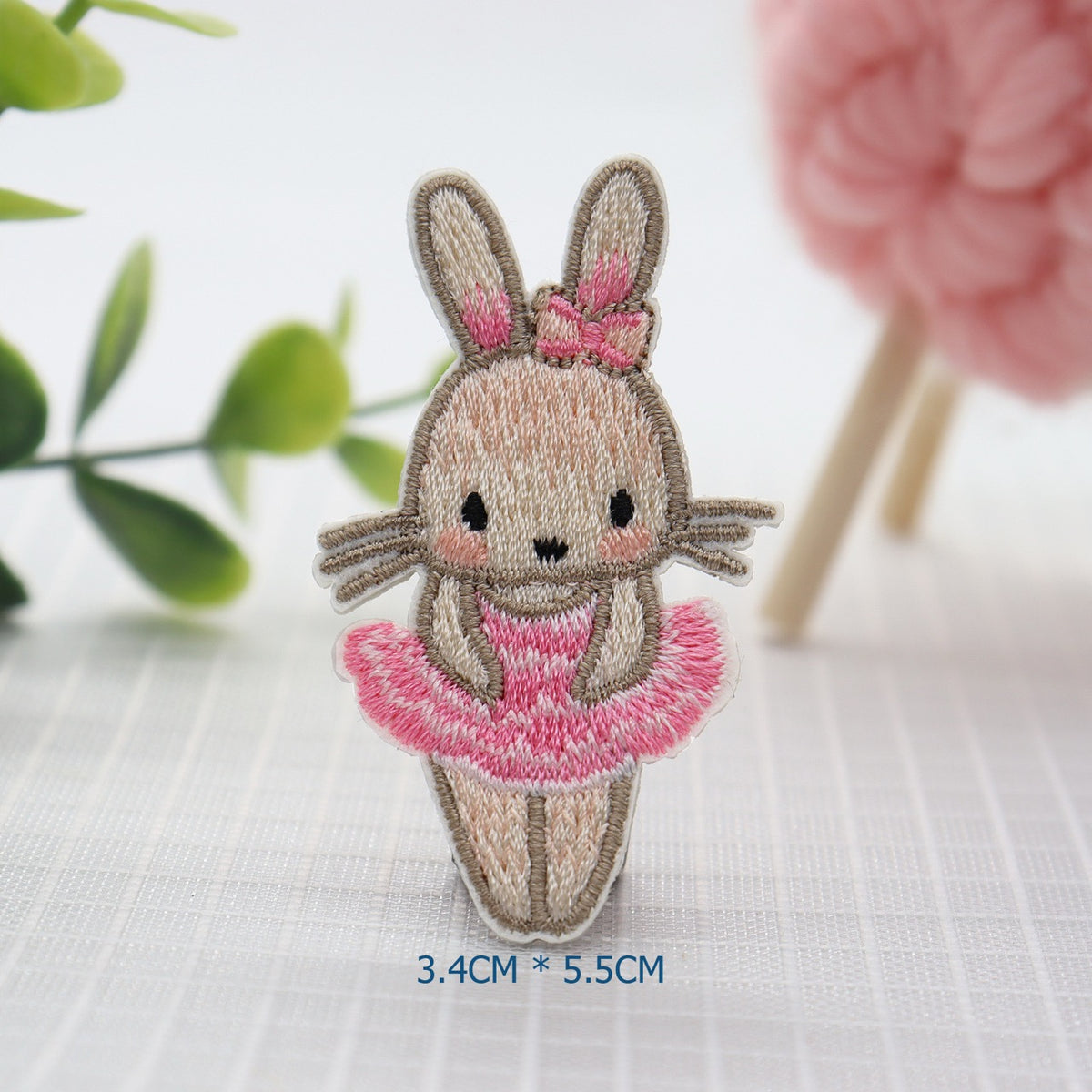 Ballerina bunny embroidered patch wearing a pink tutu and matching bow between upright ears
