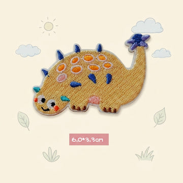 yellow Ankylosaurus kawaii embroidered stick-on patch — low wide yellow ankylosaur covered in round colorful armor plates tail curled upward