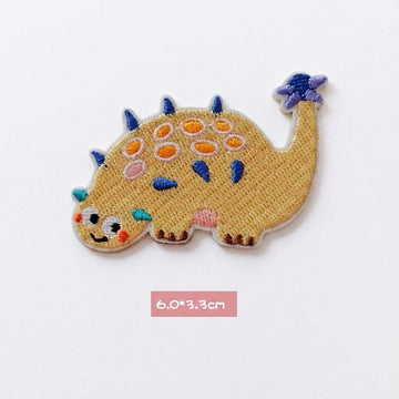 yellow Ankylosaurus kawaii embroidered stick-on patch — low wide yellow ankylosaur covered in round colorful armor plates tail curled upward