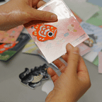 peeling and applying a Japanese koi fish embroidered stick-on patch — texture and stitching close-up