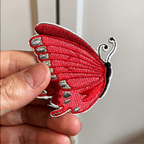 hand displaying four vibrant butterfly patches with bold saturated wing colors intricate vein patterns and rich embroidery texture in packaging with fine embroidery detail animated