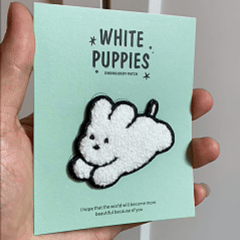 animated hand holding packaged maltese and bichon white puppies embroidered patches showing three styles and detailed embroidery texture