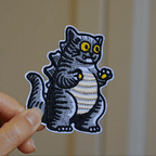 animated close-up of cat godzilla embroidered patch bold stitching and texture detail