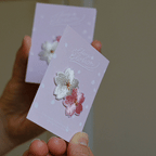 peeling and applying a sakura cherry blossom stick-on patch — embroidery texture close-up