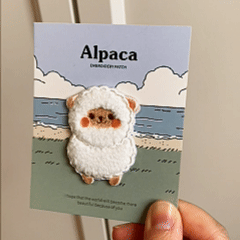 animated hand holding packaged alpaca embroidered patches showing detailed embroidery texture