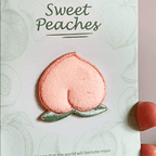 animated hand holding packaged sweet peaches embroidered patches showing two styles and detailed embroidery texture