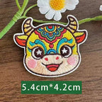 Chinese zodiac ox embroidered stick-on patch — teal and gold headdress composed expression symmetrical forehead decoration