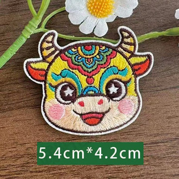 Chinese zodiac ox embroidered stick-on patch — teal and gold headdress composed expression symmetrical forehead decoration