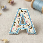 close-up detail of floral alphabet letter A embroidered stick-on patch with ditsy floral fabric fill