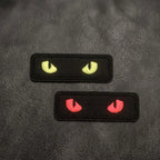 glow-in-the-dark cat eye embroidered stick-on patches — yellow and red on black, 73 × 24mm size reference