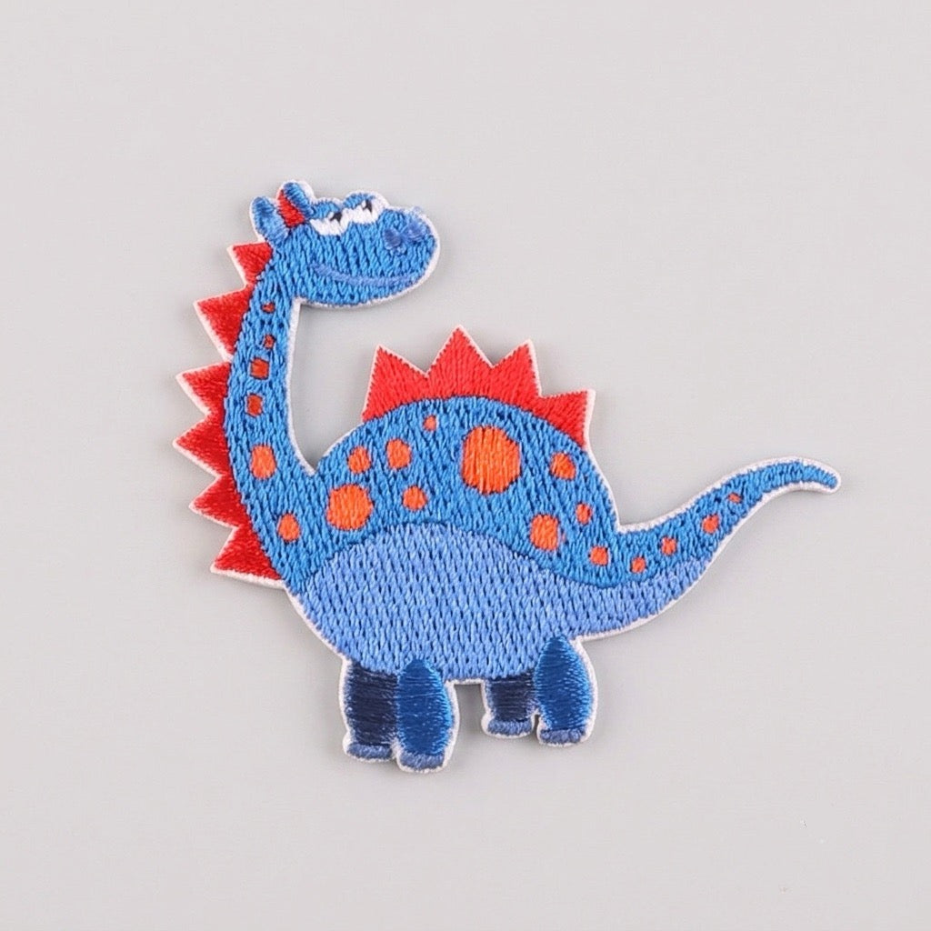 cute colorful blue dinosaur embroidered stick-on patch with red spikes and orange spots