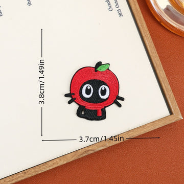 Black cat embroidered stick-on patch wearing a red apple hood with a green leaf
