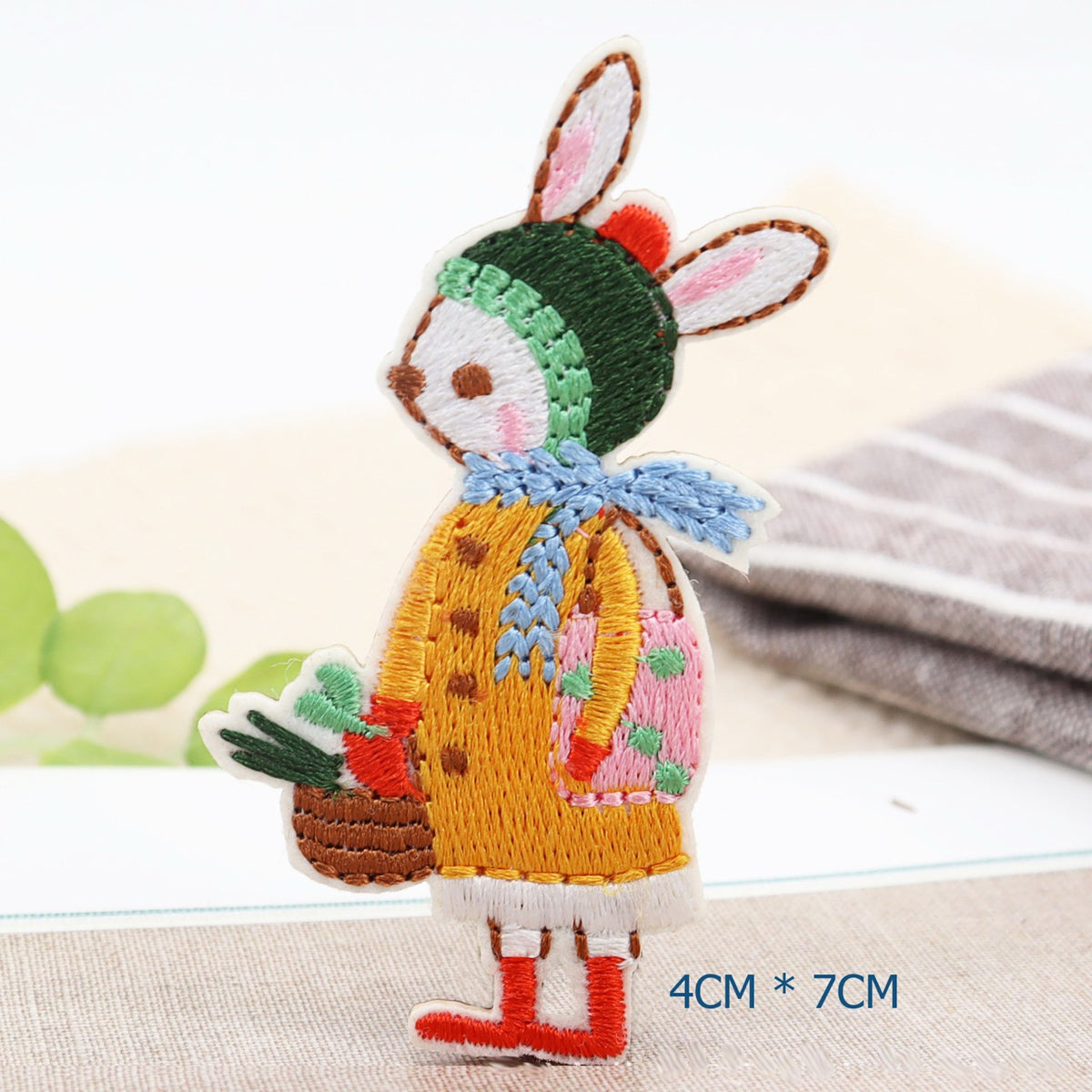 Winter bunny embroidered patch with a green hat, blue scarf, red boots, and vegetable basket
