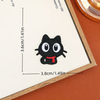 Wide-eyed sitting black cat embroidered stick-on patch with a tucked tail and red scarf
