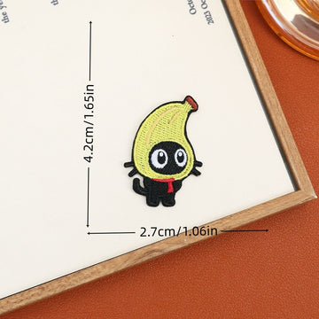 Banana-costumed black cat embroidered stick-on patch with oval white eyes and a curled tail
