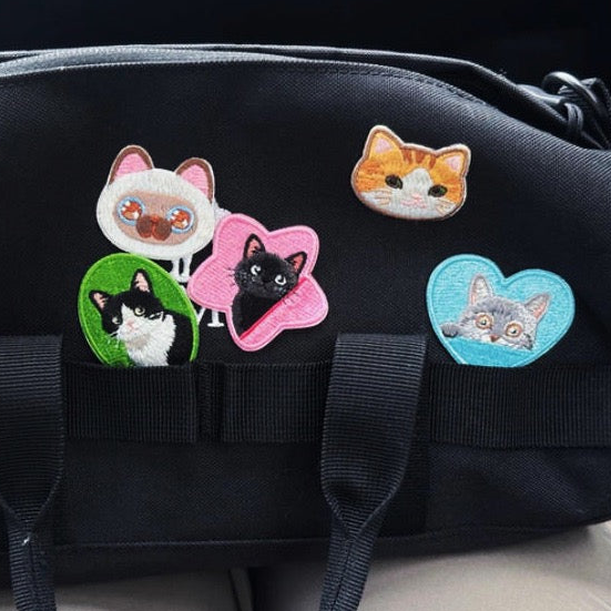 cute cat face embroidered stick-on patch on a bag