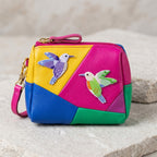 purple and green hummingbird embroidered patches on a colorblock leather wristlet pouch