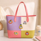 penguin in orange peach pineapple lemon and apple costume stick-on patches decorating a purple and pink color-block leather handbag