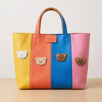 fluffy teddy bear face embroidered stick-on patches on a yellow orange blue and pink striped tote bag
