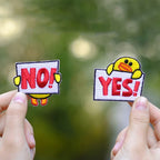 holding a yes or no duck embroidered stick-on patch in hand