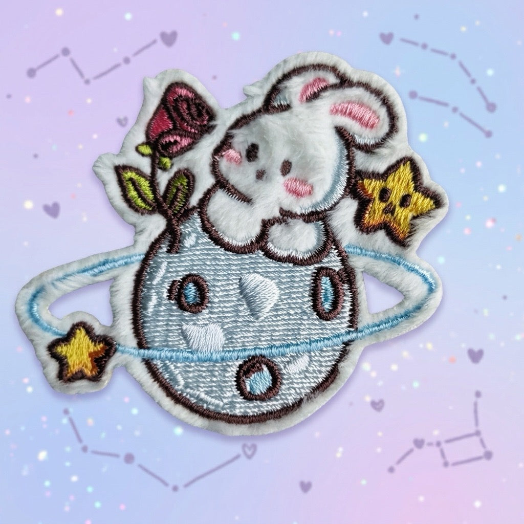 cute space bunny embroidered stick-on patch — white bunny on blue ringed planet with pink rose and gold stars raised velvety embroidery
