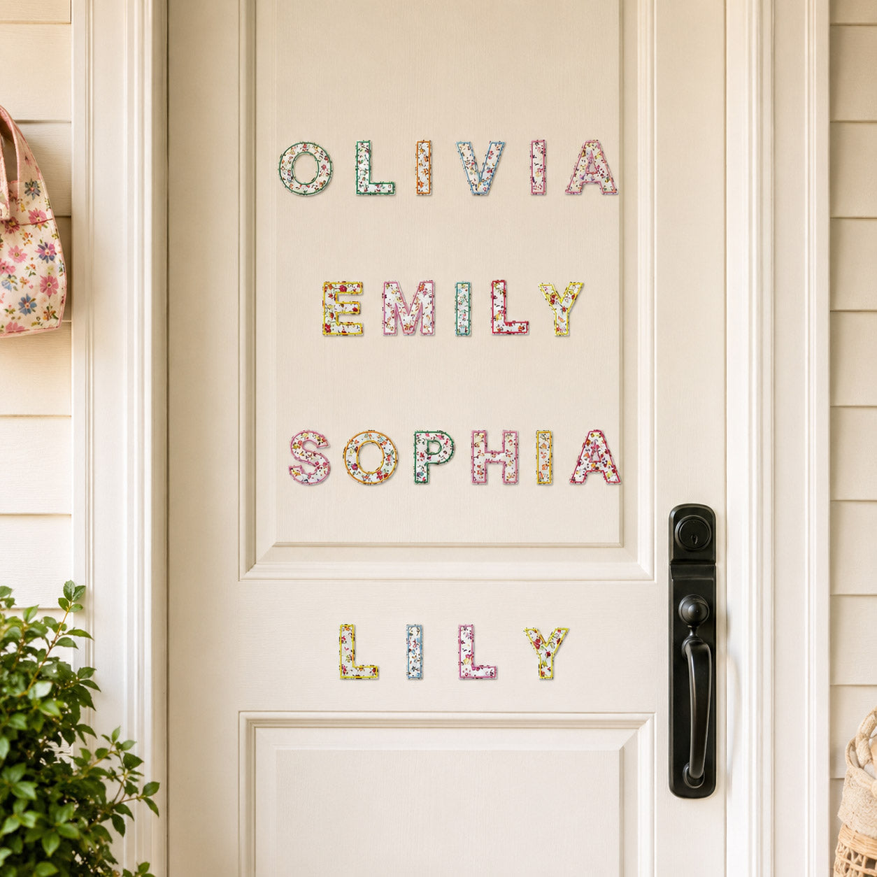 colorful ditsy floral print letter patches arranged into custom names on a cream entryway door in an outdoor setting