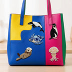 marine animal embroidered stick-on patches on a colorful color-block leather tote bag