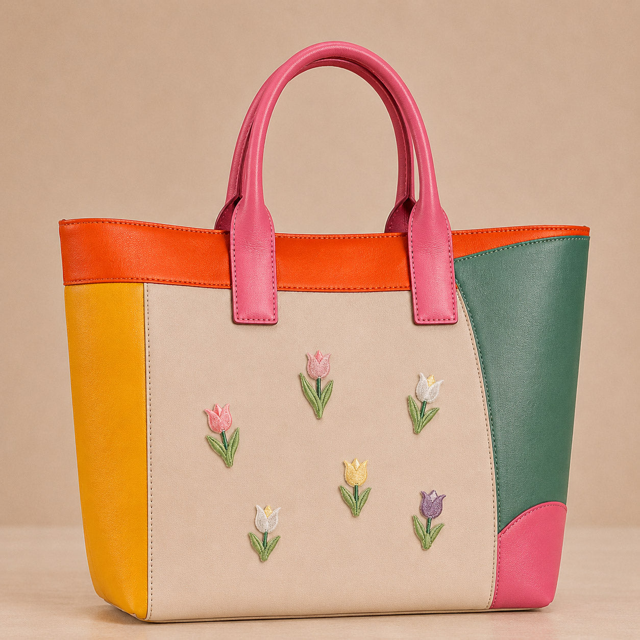 pink white yellow and purple tulip stick-on patches scattered on a pink and orange color-block leather handbag