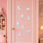 fluffy white harp seal pup stick-on patches with black eyes and blue border stitching in eight poses on a pink door in a pastel girls room