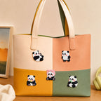 five kawaii celebrity panda embroidered patches on a cream pink orange yellow and green color-block leather tote bag