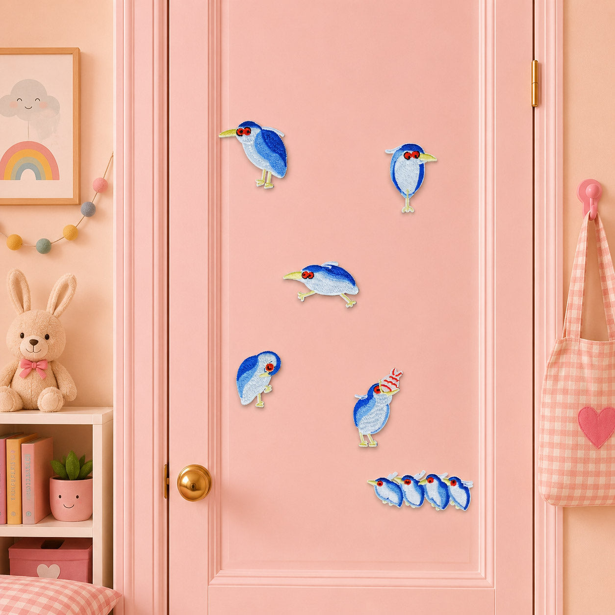 chubby blue gray night heron with red eyes in six poses including birthday hat and four birds in a row stick-on patches on a pink door in a pastel room
