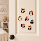 fluffy chenille penguin in raccoon pumpkin hat bow tie and knit cap stick-on patches scattered on a cream bedroom door