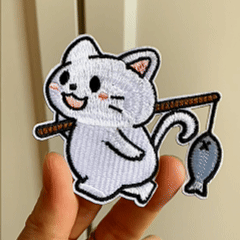 Animated hand holding three cute fishing cat embroidered stick-on patches
