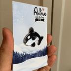 animated hand holding packaged killer whale diving marine creatures embroidered patch showing detailed embroidery texture