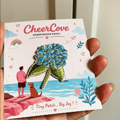 animated hand holding packaged cottagecore floral hydrangea daisy embroidered patches showing detailed embroidery texture