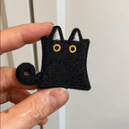 animated hand holding packaged funny peeking black cat embroidered patches showing three styles and detailed embroidery texture