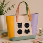 black owl dnd smiley face and red panda icon stick-on patches decorating a yellow and purple color-block leather handbag